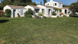 A white villa with a tiled roof, surrounded by a well-maintained lawn and garden. - Charming house close to the beach, (L'Île-d'Yeu)