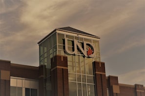 A building with a prominent 'UND' logo on its facade. - The Gateway - a Beautiful Relaxing Three Bedrooms Apartment (Grand Forks)