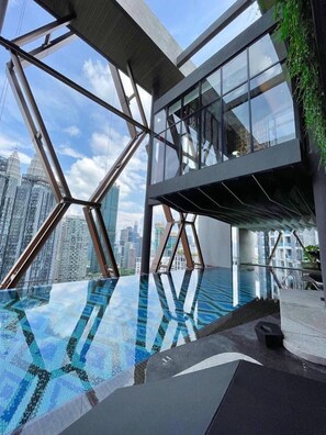 A modern building with a glass facade and a rooftop pool. - Deluxe Studio Scarletz Suites Klcc (Kuala Lumpur)