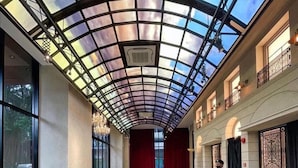 Un'ampia hall con soffitto in vetro, una reception e un'area salotto.