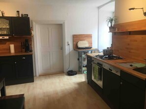 A compact kitchen with a stove, sink, and wooden cabinets.