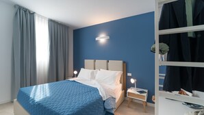 A bedroom with a bed, bedside tables, and a wardrobe. - Stylish Residenza Torre Bianca 2 Bedroom Sleeps 6 (Lignano Sabbiadoro)