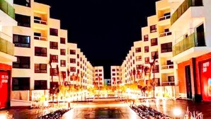 Un hotel moderno con un cortile interno, diversi piani e una facciata ben illuminata.