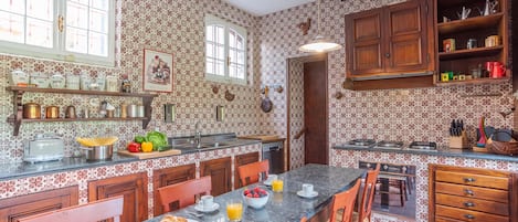 A kitchen with a central island, wooden cabinets, and a patterned backsplash.