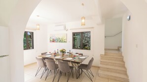 A dining area with a table set for four, surrounded by chairs, with a staircase leading to another level. - Protaras Holiday Villa My5 (Paralimni)