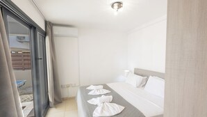 A hotel room with a bed, a window, and a door. - Protaras Holiday Villa My5 (Paralimni)