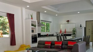 A modern living room with a sofa, a coffee table, and a blue rug. - Phikun Private Pool Villa (Chalong)
