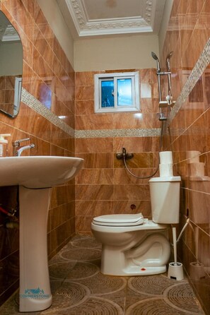 A bathroom with a sink, toilet, and shower.