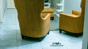 Un salón con dos sillones, un televisor y una estantería blanca.
