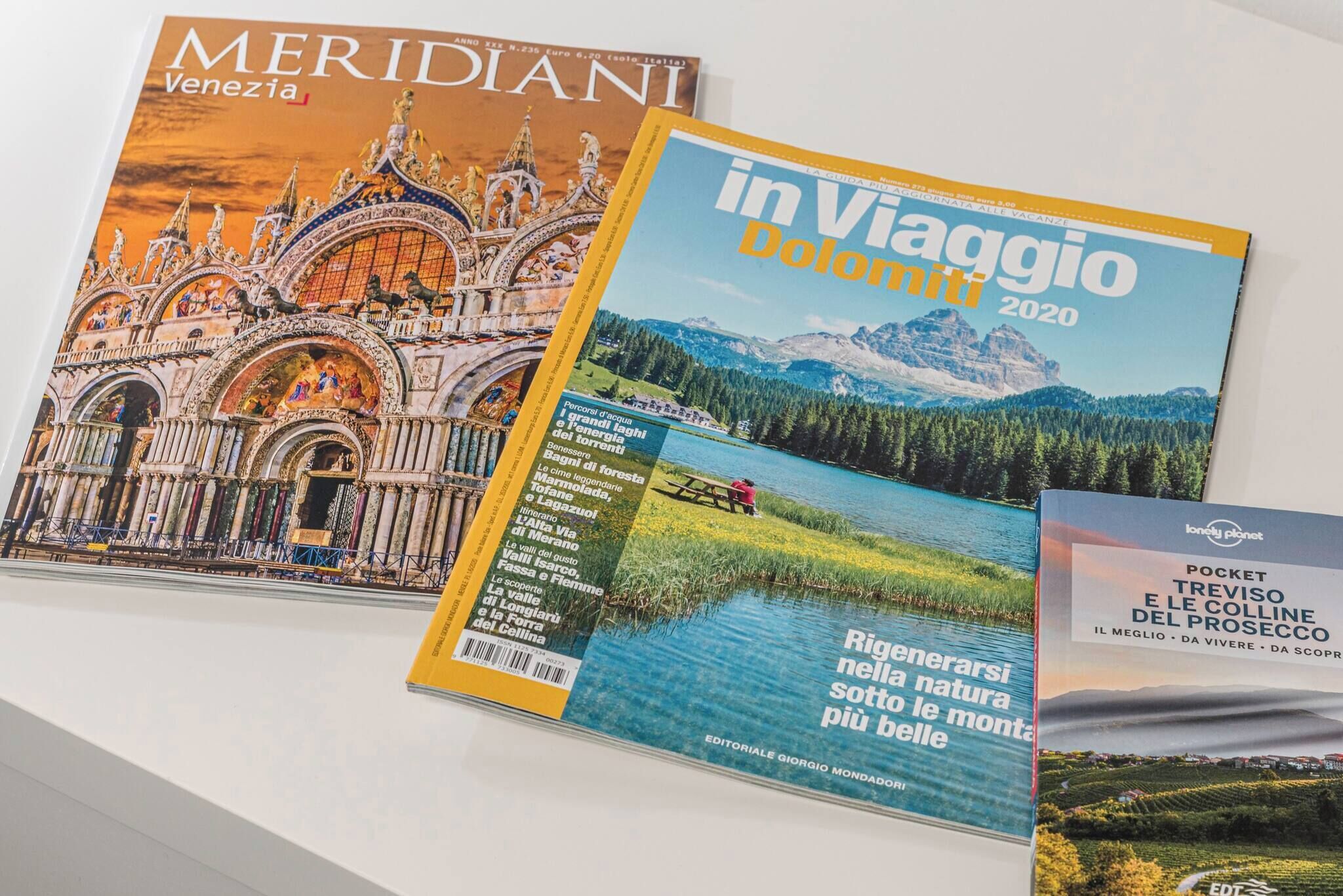 Three travel magazines with covers featuring architectural and natural landscapes.