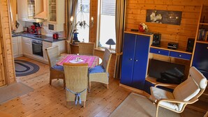 Un intérieur de chalet chaleureux comprenant un coin repas, une cuisine et un espace salon.
