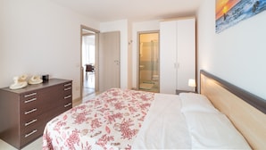 A bedroom with a bed, a dresser, a shower, and a painting on the wall. - Super Family Friendly Villaggio Planetarium Resort 2 Bedroom Sleeps 6 (San Michele al Tagliamento)