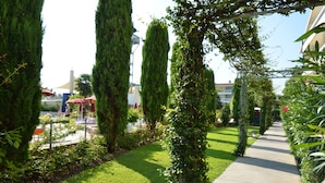 A pathway lined with tall, narrow trees and a well-maintained lawn. - Super Family Friendly Villaggio Planetarium Resort 2 Bedroom Sleeps 6 (San Michele al Tagliamento)