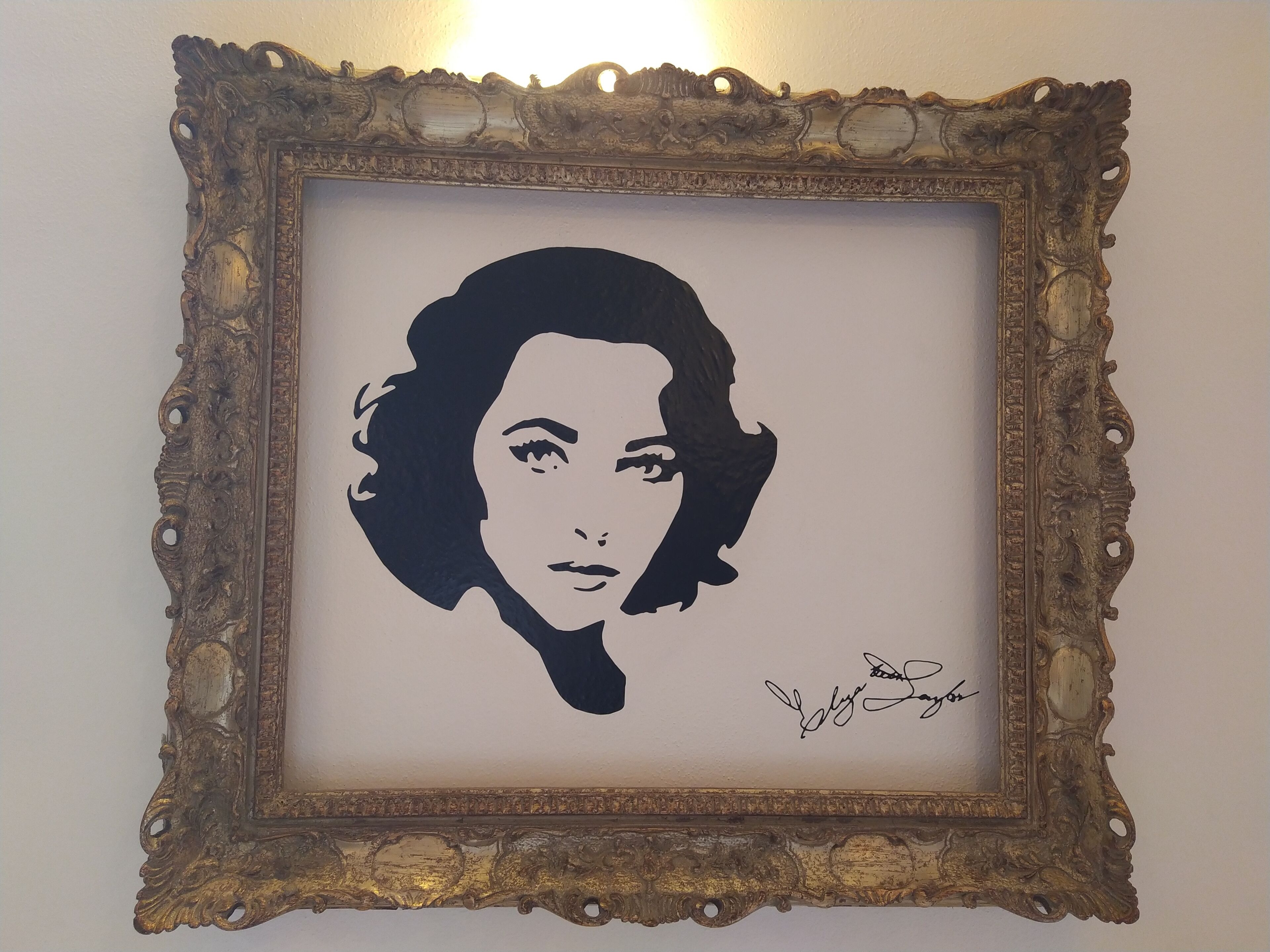 Une œuvre d’art encadrée, portant une signature en bas à droite.