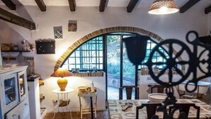 A rustic dining area with a table, chairs, and a lamp.