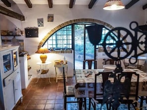 A rustic dining area with a table, chairs, and a lamp. - Villa Cefalù Private Pool (Cefalù)