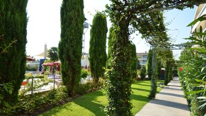 A pathway lined with tall, narrow trees and a well-maintained lawn. - Super Villaggio Planetarium Resort 1 Bedroom Apartment Sleeps 4 (San Michele al Tagliamento)