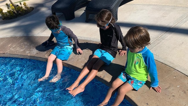 Three children sitting by a pool with a concrete edge. - Room-appartment Rodolfo Historical Centr (Mazatlán)