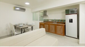 A compact kitchen with a dining area, a built-in oven, a microwave, and a refrigerator. - Room-appartment Rodolfo Historical Centr (Mazatlán)