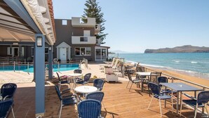 A beachfront hotel with a pool, outdoor seating, and a view of the sea. - Room in Guest Room - Girogiali Beach Hotel (Chania)