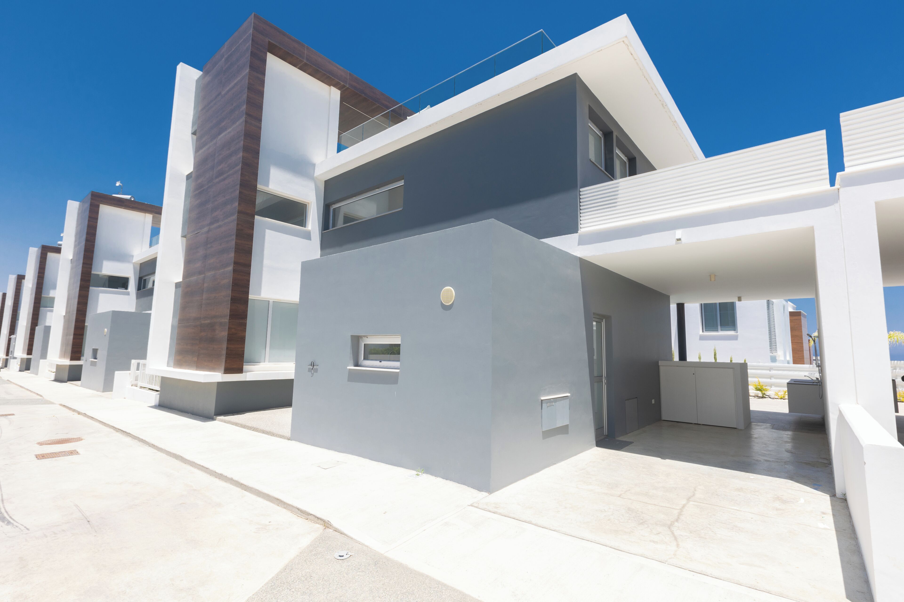 A modern residential building with a flat roof, large windows, and a clean, minimalist design.