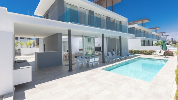 A modern two-story house with a swimming pool, outdoor seating, and a balcony. - Protaras Olivine Villa Ol9 (Paralimni)