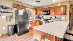 Una cocina moderna con armarios de madera, electrodomésticos de acero inoxidable y una isla grande.