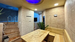 Een moderne badkamer met een houten wastafelmeubel, een rond dakvenster en een douchehoek.