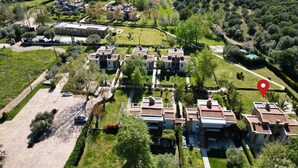 Luchtbeeld van een woongebied met meerdere gebouwen, een heldere blauwe lucht en een waterpartij op de achtergrond.