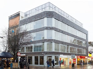 Stylish commercial building with retail stores and large windows.