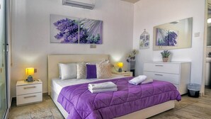 Una camera da letto con un letto, comodini, una cassettiera e opere d'arte alle pareti.