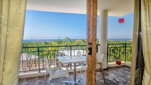 Un balcone con tavolo e sedie, vista sul mare e ringhiera.