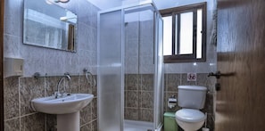 Ein Badezimmer mit Glasdusche, Waschbecken und Toilette.