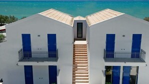 A white building with blue shutters and a central staircase leading to a door. - Dolce Mare 4 - Sea Front - Large Balcony - Sandy Beach (Modica)