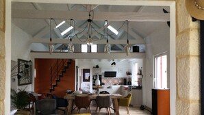 Un vaste espace de vie comprenant une table à manger, des chaises et un escalier menant à l’étage supérieur.