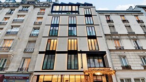 A multi-story building with large windows and balconies. - CARD Hôtel (Paris)