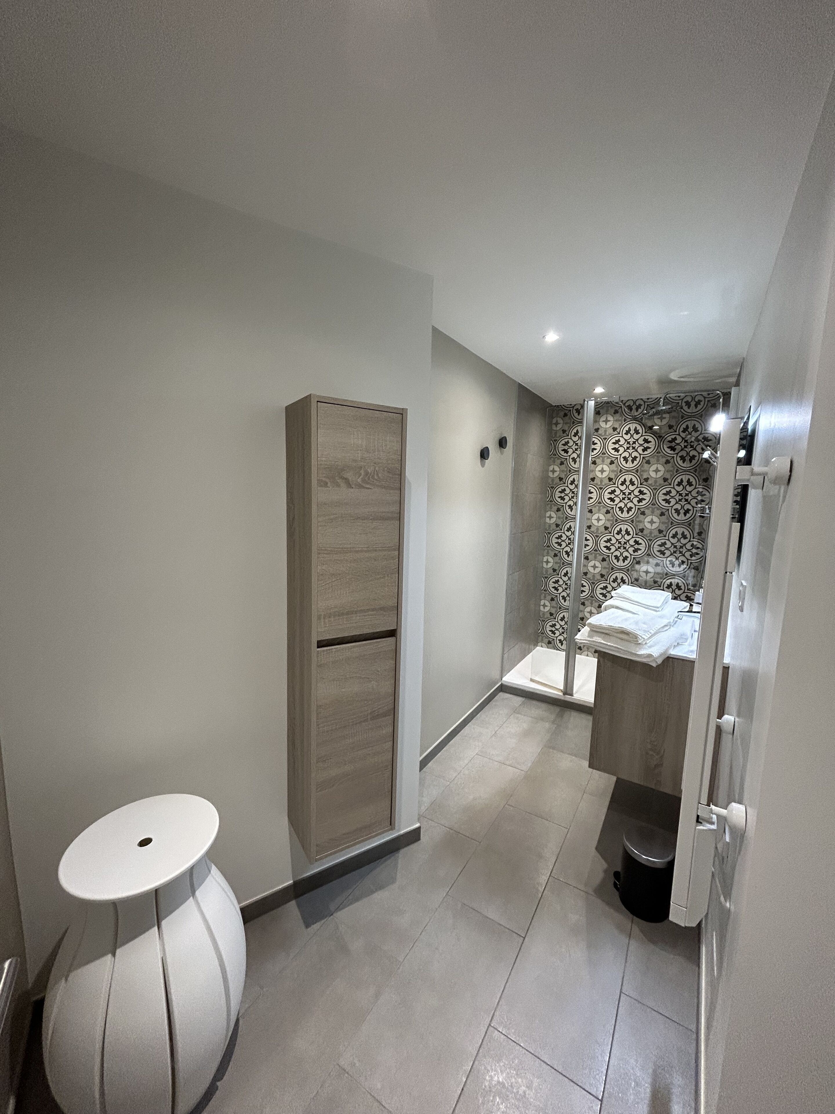 Et moderne badeværelse med bruser, toilet og håndvask.