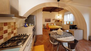 A compact kitchen with a gas stove, a sink, and a tiled backsplash. - Siena UP Town: Sabrina's Lovely apartment (Siena)