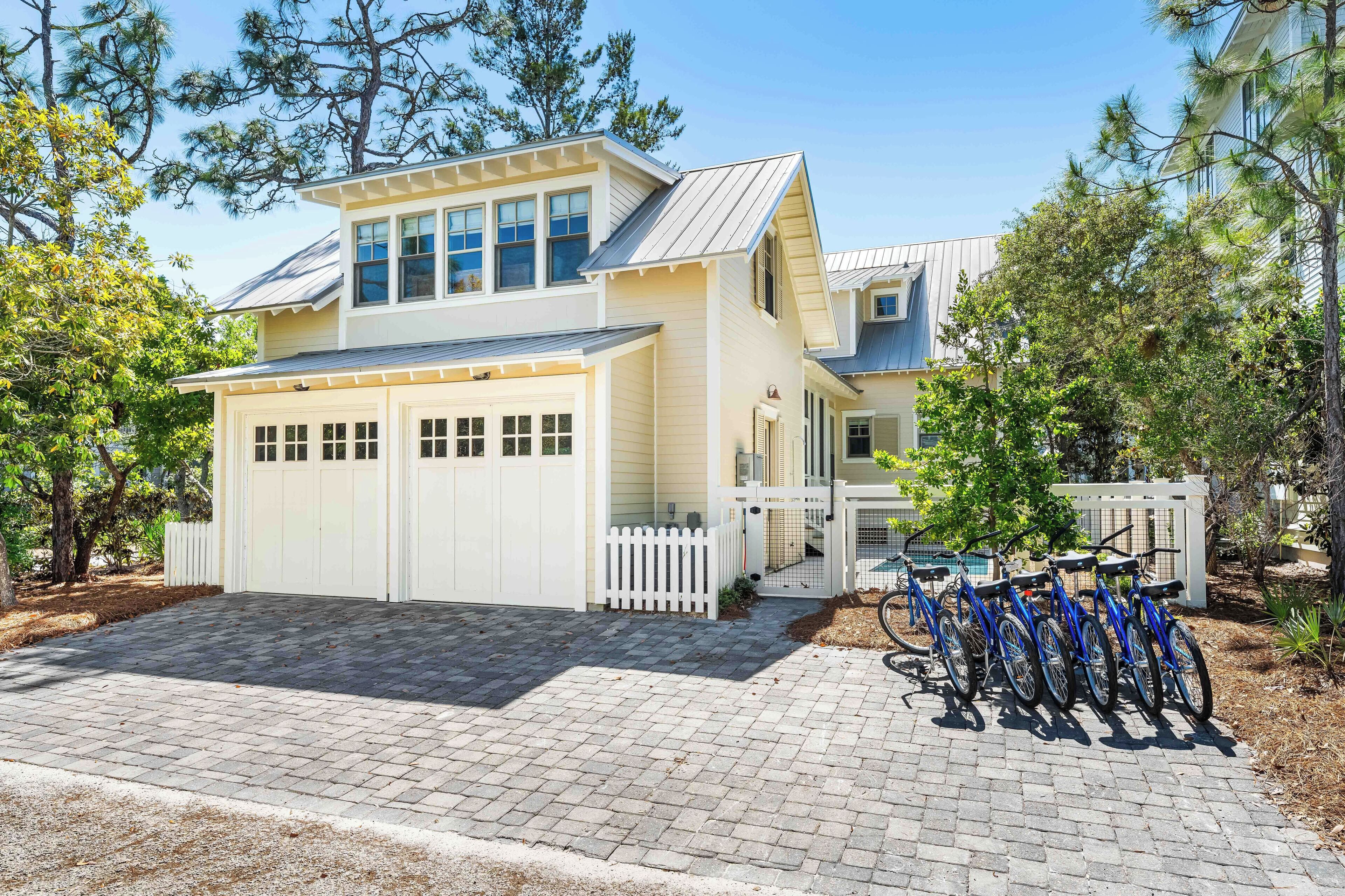 Een twee verdiepingen tellend huis met een garage, een overdekte veranda en een fietsenrek.