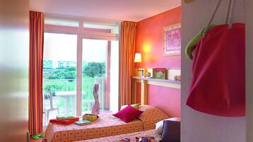 Ein kindgerechtes Zimmer mit zwei Betten, einem Balkon und Blick ins Grüne.