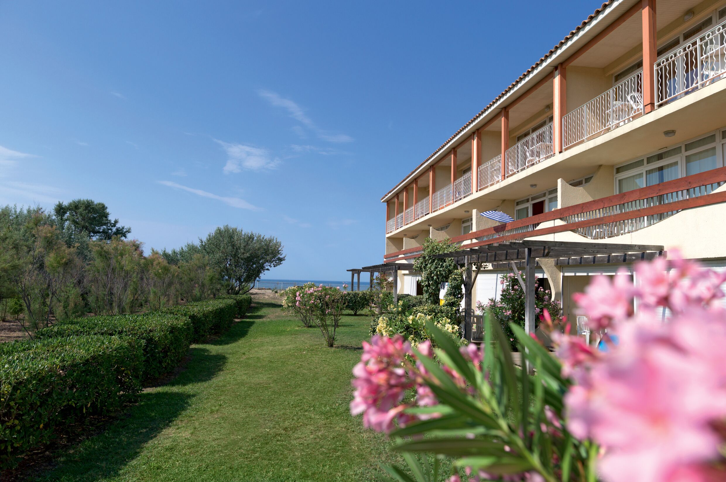 A hotel with a garden and a view of the sea.