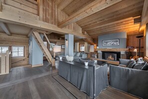 Familie chalet | Woonkamer | Een plasmatelevisie, een open haard, een computer en vloerverwarming