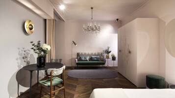 Une chambre d’hôtel moderne équipée d’une table à manger, d’un canapé, d’un lustre et d’une grande armoire.