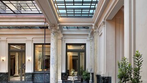 Un vestíbulo amplio con techo alto, ventanas grandes y una zona de estar central.