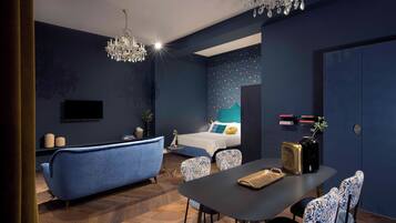 Une chambre moderne avec un grand lit, une coiffeuse et un coin repas comprenant des chaises et une table.