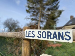 Un letrero con la inscripción 'LES SORANS' sobre un poste de madera.