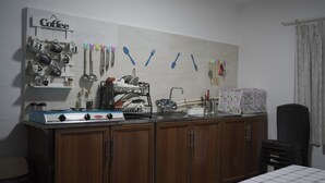 A kitchen with wooden cabinets, a stove, and a wall-mounted dish rack. - Petra Triclinium Home (Wadi Musa)