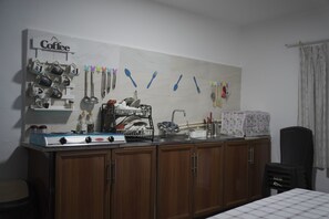 Een koelkast met diepvriezer, een microgolfoven, een kookplaat