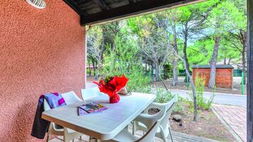 Relax in this serene outdoor seating area with a table and chairs, perfect for reading or enjoying a moment to yourself.