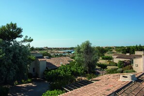 Residential area with homes, lush gardens, and a scenic view of a nearby body of water.